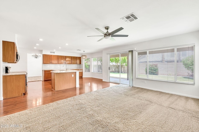 664 E Windsor Dr, Gilbert, AZ 85296 - kitchen with open floor plan, light countertops, ceiling fan, a sink, and brown cabinets