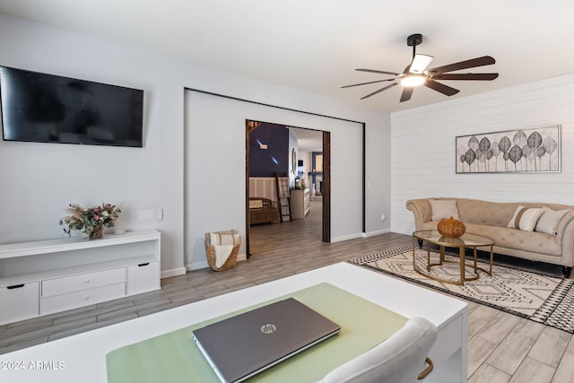 living room featuring light hardwood / wood-style floors and ceiling fan