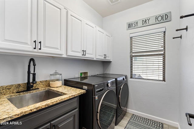 laundry area with cabinets, washer and dryer, sink, and light tile patterned floors