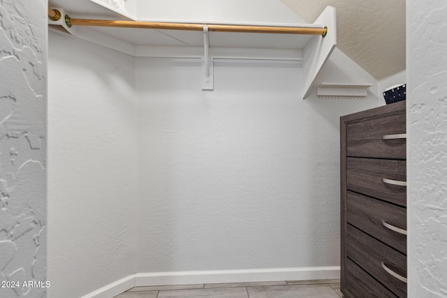 walk in closet with light tile patterned floors