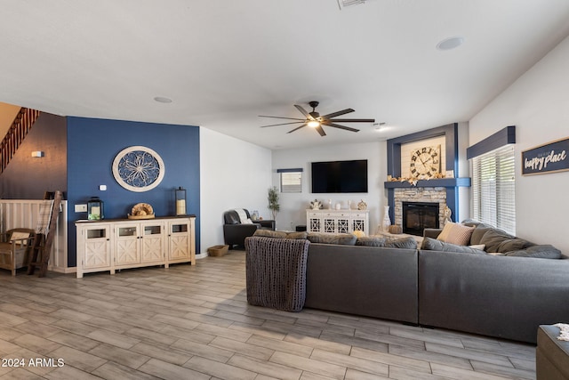 living room with light hardwood / wood-style floors, a fireplace, and ceiling fan