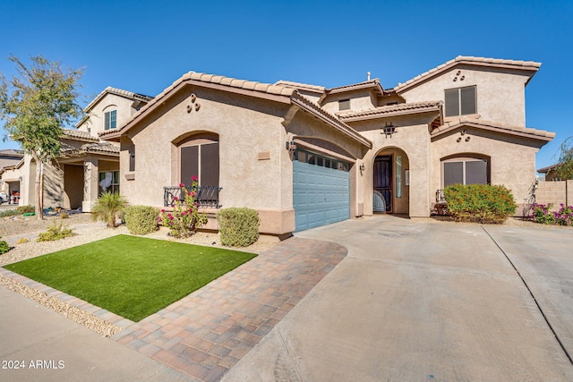 mediterranean / spanish house with a front yard and a garage