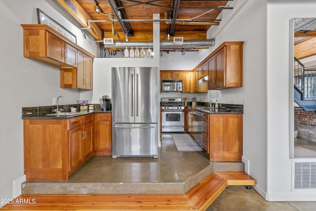 kitchen with appliances with stainless steel finishes, concrete floors, and sink