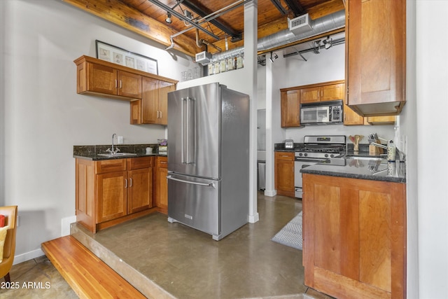 kitchen with dark stone counters, sink, and stainless steel appliances