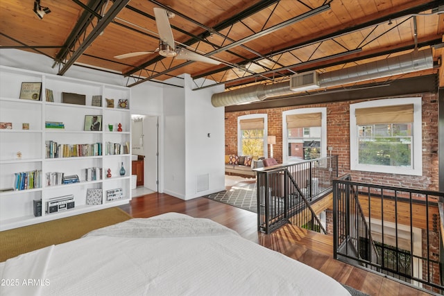 bedroom with wood ceiling, dark hardwood / wood-style flooring, and brick wall