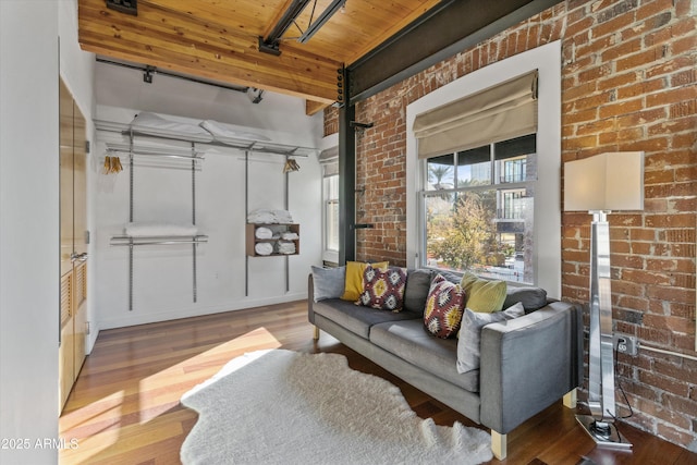 living room with hardwood / wood-style floors, wooden ceiling, and brick wall