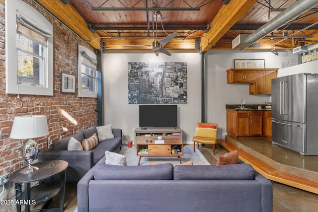 living room with sink, wooden ceiling, beamed ceiling, brick wall, and concrete floors