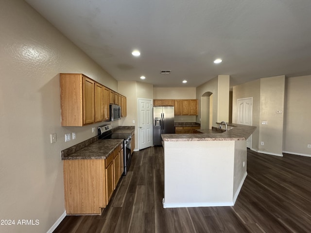 kitchen featuring sink, an island with sink, stainless steel appliances, and dark hardwood / wood-style floors