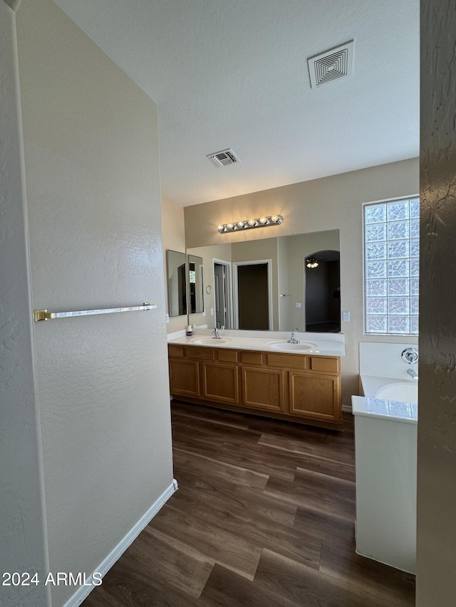 bathroom featuring a tub to relax in, vanity, and hardwood / wood-style flooring