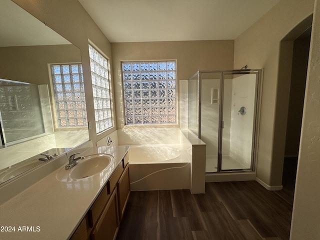 bathroom with separate shower and tub, vanity, and wood-type flooring