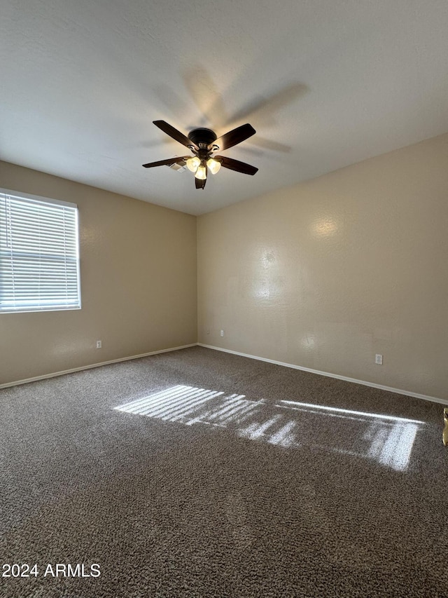 empty room featuring carpet floors and ceiling fan