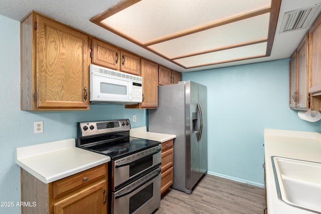 2146 W Isabella Ave Unit 131, Mesa, AZ 85202 - kitchen featuring a sink, light wood-type flooring, baseboards, visible vents, and appliances with stainless steel finishes