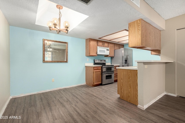 2146 W Isabella Ave Unit 131, Mesa, AZ 85202 - kitchen featuring wood finished floors, an inviting chandelier, stainless steel appliances, light countertops, and a peninsula