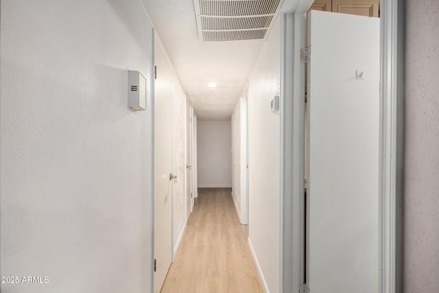 hall featuring visible vents and light wood-style flooring