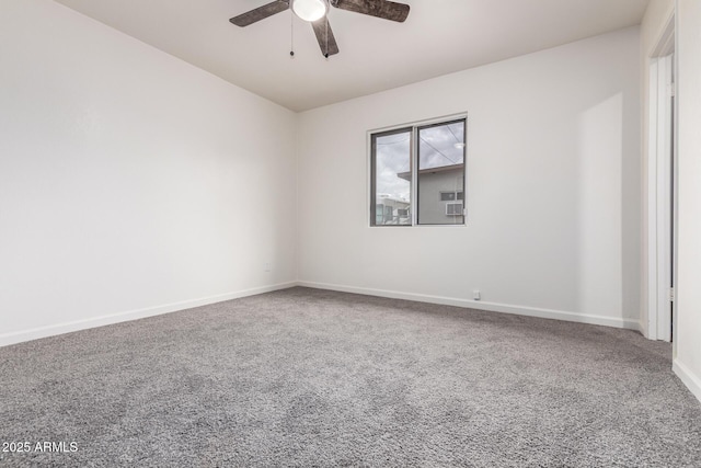 carpeted empty room featuring a ceiling fan and baseboards