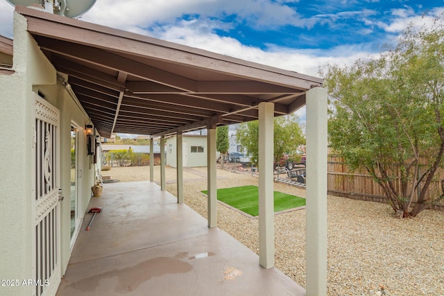 view of patio featuring an outdoor structure and fence