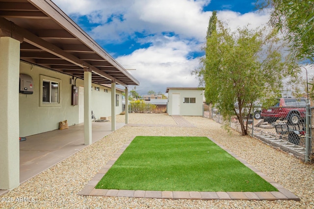 view of yard featuring a patio area, a storage unit, an outdoor structure, and a fenced backyard