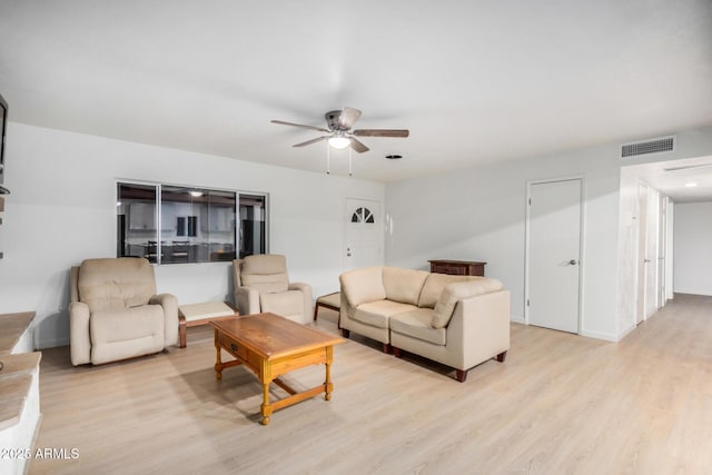 living area featuring baseboards, visible vents, light wood finished floors, and ceiling fan