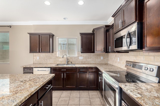23789 W Chipman Rd, Buckeye, AZ 85326 - kitchen with ornamental molding, light tile patterned floors, decorative backsplash, stainless steel appliances, and a sink