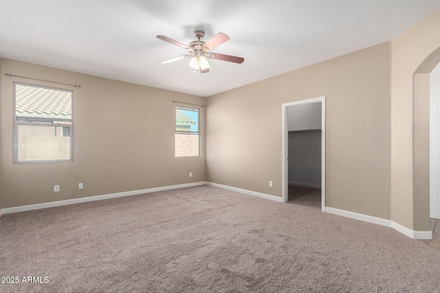 23789 W Chipman Rd, Buckeye, AZ 85326 - spare room featuring arched walkways, ceiling fan, carpet flooring, and baseboards
