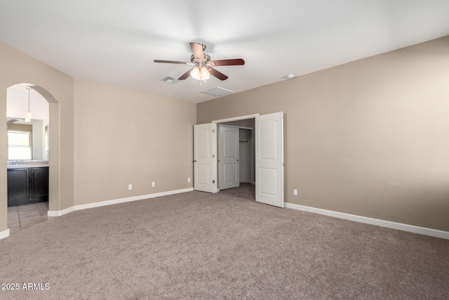 23789 W Chipman Rd, Buckeye, AZ 85326 - unfurnished bedroom with arched walkways, carpet flooring, baseboards, and visible vents
