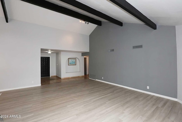 unfurnished living room with vaulted ceiling with beams and light hardwood / wood-style floors