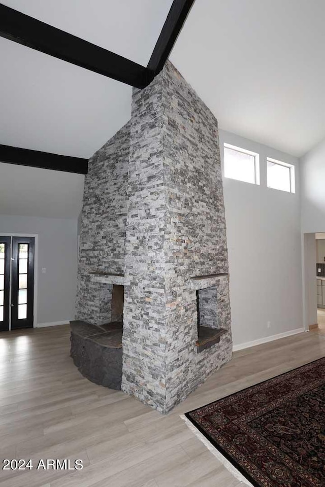 7331 E Valley Vista Dr, Scottsdale, AZ 85250 - unfurnished living room with high vaulted ceiling, beamed ceiling, a stone fireplace, healthy amount of natural light, and baseboards