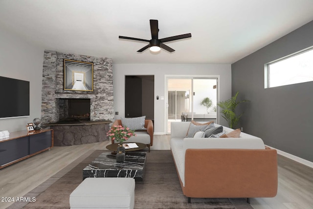 living room featuring dark hardwood / wood-style floors, ceiling fan, and a fireplace