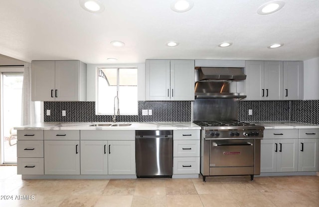 kitchen with wall chimney range hood, sink, gray cabinets, tasteful backsplash, and stainless steel appliances