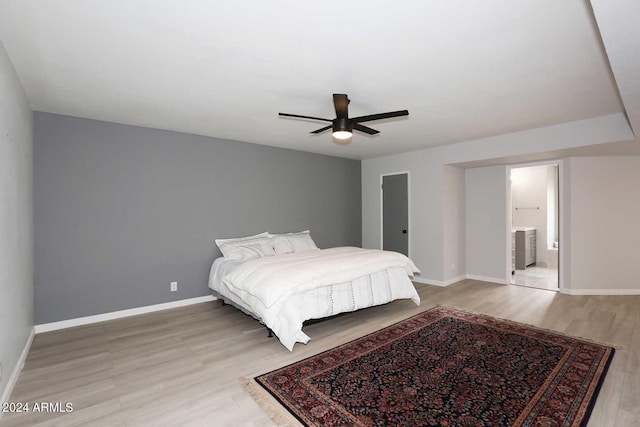 bedroom with hardwood / wood-style floors, ceiling fan, and ensuite bath