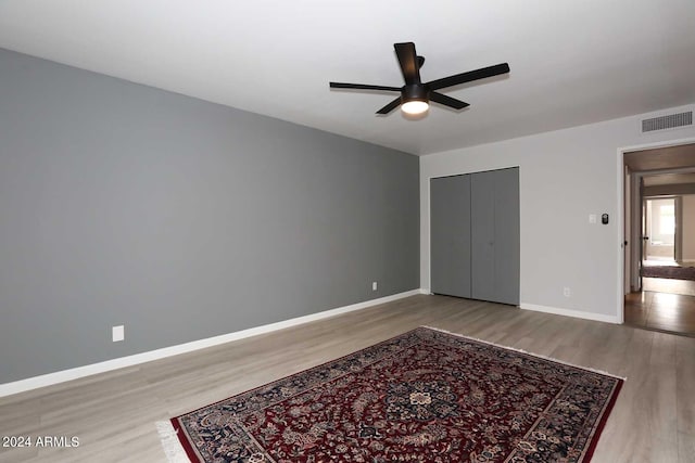 bedroom featuring wood-type flooring, a closet, and ceiling fan