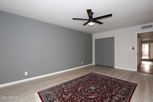 7331 E Valley Vista Dr, Scottsdale, AZ 85250 - unfurnished bedroom with wood finished floors, baseboards, a closet, and a ceiling fan