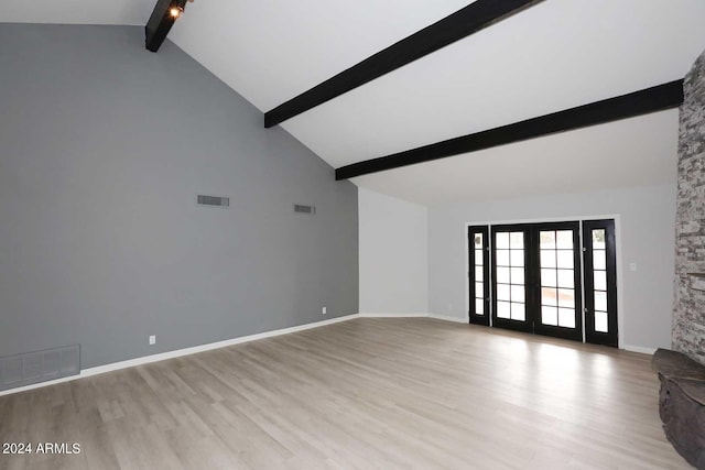 unfurnished living room with beam ceiling, light wood-type flooring, high vaulted ceiling, and french doors