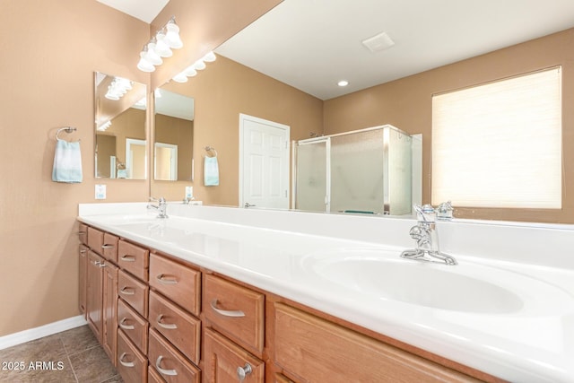 bathroom featuring double vanity, tile patterned flooring, a shower stall, and a sink