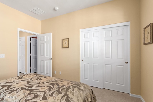 bedroom featuring light colored carpet, a closet, and visible vents