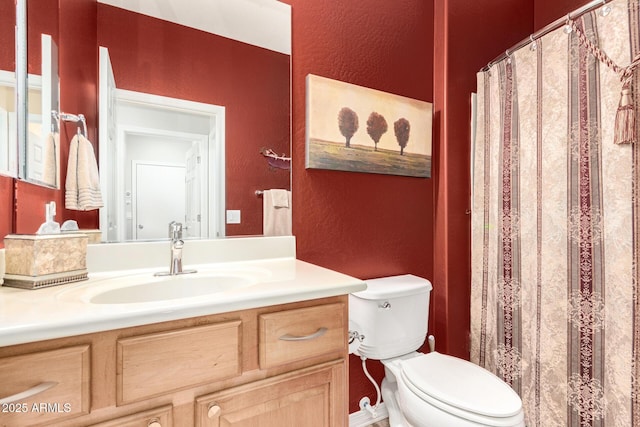 full bathroom with a textured wall, a shower with shower curtain, vanity, and toilet