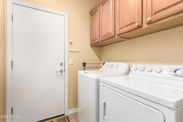 laundry area featuring cabinet space, baseboards, and separate washer and dryer