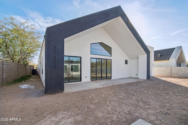 rear view of house featuring central AC, a fenced backyard, stucco siding, and a patio area