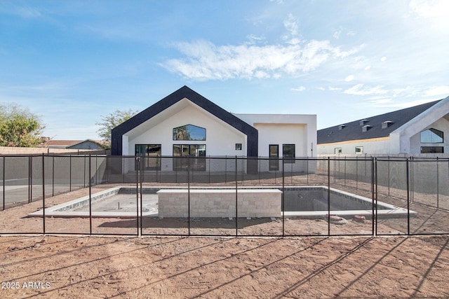 back of property with stucco siding and fence