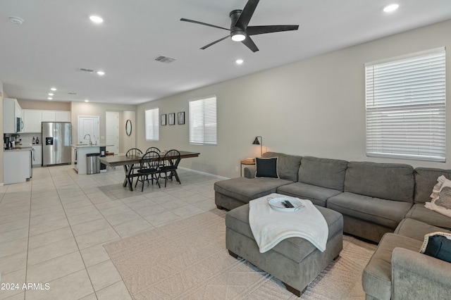 living room with light tile patterned floors, ceiling fan, a healthy amount of sunlight, and sink