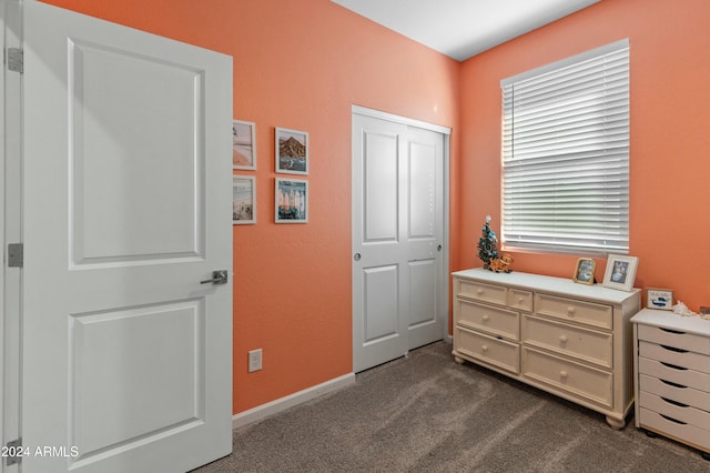 bedroom with a closet and dark carpet