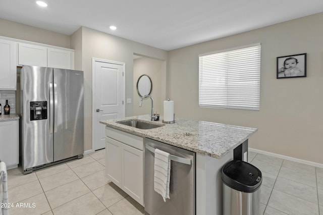 kitchen with white cabinetry, sink, light stone counters, a center island with sink, and appliances with stainless steel finishes