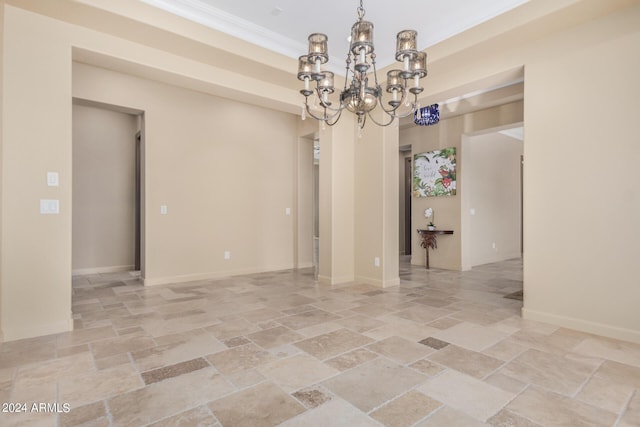 empty room featuring crown molding and a chandelier