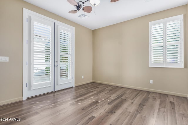 empty room featuring ceiling fan, french doors, and wood-type flooring