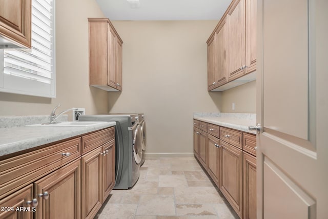 laundry area with separate washer and dryer, sink, and cabinets