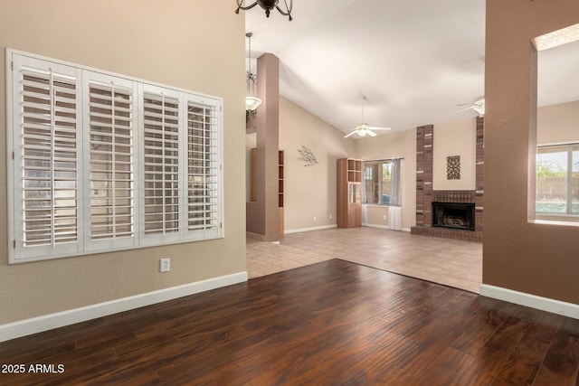 2753 E Kenwood St, Mesa, AZ 85213 - unfurnished living room with baseboards, a ceiling fan, a fireplace, wood finished floors, and lofted ceiling