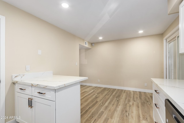 kitchen with dishwasher, light hardwood / wood-style floors, white cabinetry, and light stone countertops