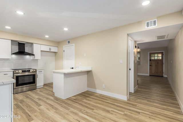 kitchen featuring white cabinetry, stainless steel range with electric stovetop, wall chimney range hood, and light hardwood / wood-style floors