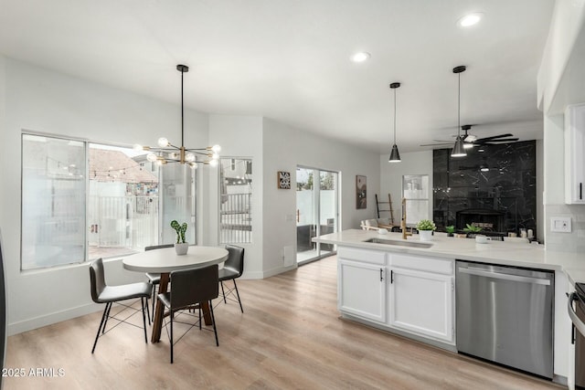 kitchen featuring stainless steel appliances, white cabinetry, light wood-type flooring, and decorative light fixtures