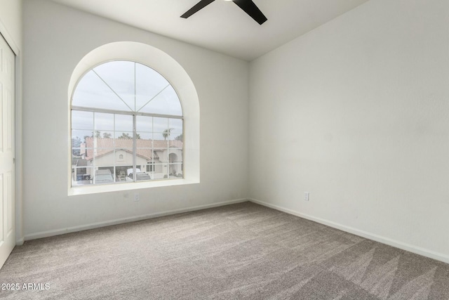 carpeted empty room featuring ceiling fan